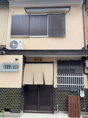 a building with two sets of doors and a fan at Y K Kyoto Nijo Traditional House close to Arashiyama in Kyoto
