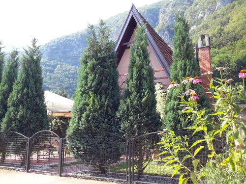 a group of trees in front of a house at Viola i Detelina Apartments in Perućac