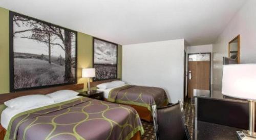 a hotel room with two beds and a desk at Super 8 By Wyndham Wayne in Wayne