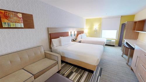 a hotel room with two beds and a couch at Home2 Suites By Hilton Phoenix-Tempe University Research Park in Tempe