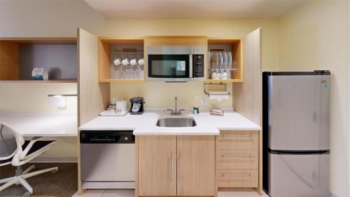 a small kitchen with a sink and a refrigerator at Home2 Suites By Hilton Phoenix-Tempe University Research Park in Tempe