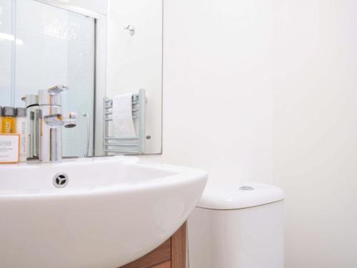 a white bathroom with a sink and a toilet at 10 Horizon View in Liskeard
