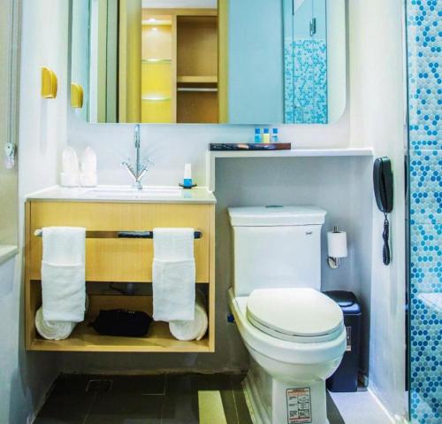a bathroom with a white toilet and a sink at Beluga Sanya Discovery Ocean World in Shangsimacun