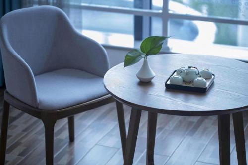 a table with a chair and a vase and a plant at Beluga Sanya Discovery Ocean World in Shangsimacun