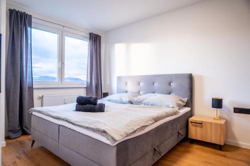 a large bed in a bedroom with a large window at Luxapartment ll Krivá in Košice