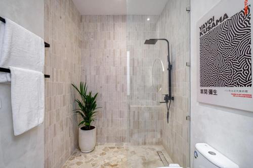 a bathroom with a shower and a potted plant at Exclusive townhouse Beachside Excellent location in Sanur
