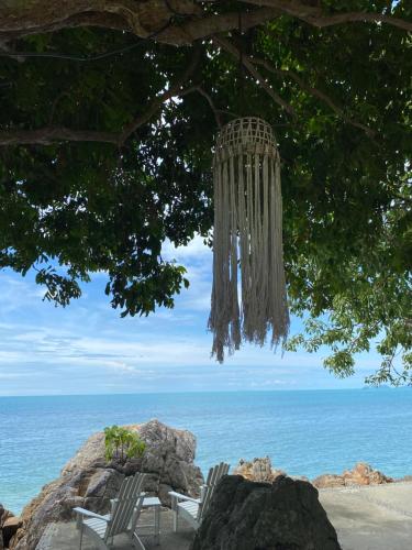a chandelier hanging from a tree on the beach at Baan Laem Noi Villa's in Mae Nam