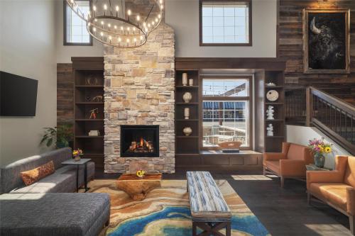 a living room with a fireplace and a couch at Starlite Yellowstone, Tapestry Collection by Hilton in West Yellowstone