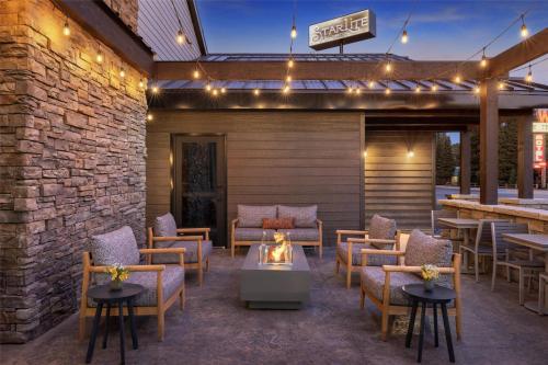 a patio with chairs and tables and a bar at Starlite Yellowstone, Tapestry Collection by Hilton in West Yellowstone