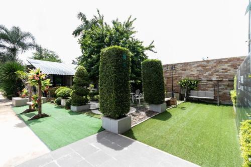 a garden with a lawn and trees and a building at OYO 75305 T Park Pak Chong in Mu Si