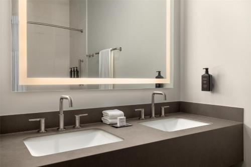 a bathroom with two sinks and a mirror at Starlite Yellowstone, Tapestry Collection by Hilton in West Yellowstone