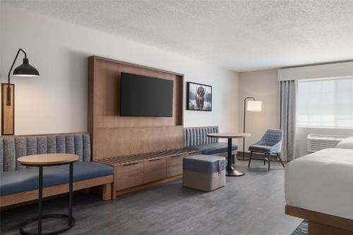a hotel room with a bed and a flat screen tv at Starlite Yellowstone, Tapestry Collection by Hilton in West Yellowstone