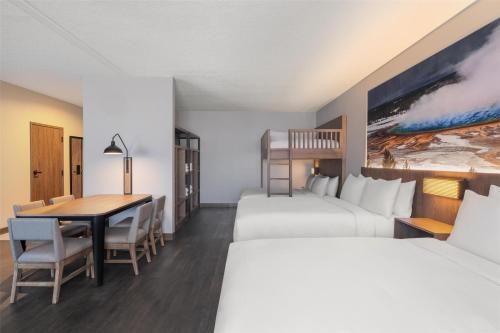 a hotel room with two beds and a desk at Starlite Yellowstone, Tapestry Collection by Hilton in West Yellowstone