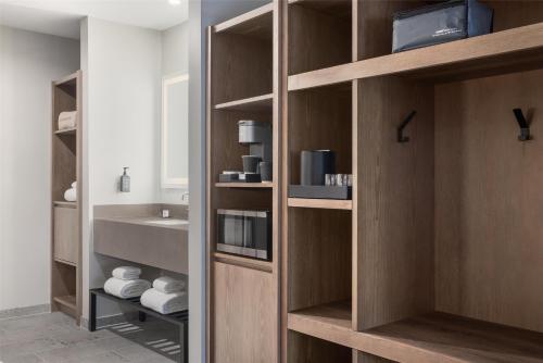 a bathroom with wooden shelves and a sink at Starlite Yellowstone, Tapestry Collection by Hilton in West Yellowstone