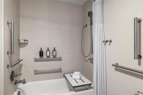 a bathroom with a shower and a toilet with two bottles at Starlite Yellowstone, Tapestry Collection by Hilton in West Yellowstone