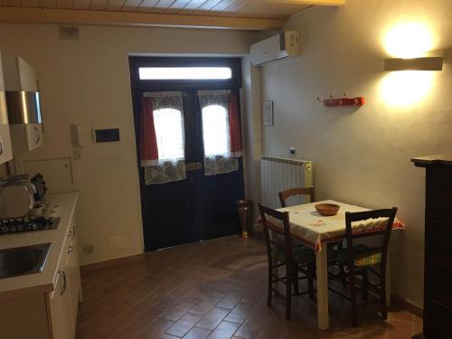 a kitchen with a table and chairs and a door at Guest House Dimora Fiorita in Serracapriola