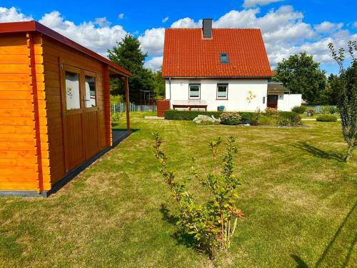a small house in a yard next to a house at Ferienhaus Wiesenblick in Hüttenrode