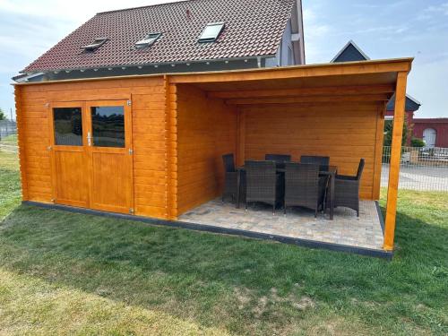 a wooden shed with a table and chairs in a yard at Ferienhaus Wiesenblick in Hüttenrode