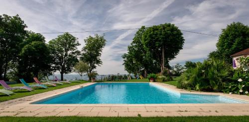 una piscina en un patio con sillas y árboles en Chambres d'hôtes Larroquinière en Port-Sainte-Marie