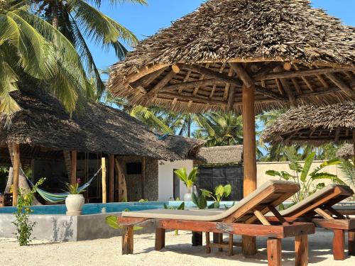 a resort with a table and chairs on the beach at Pamoja Villas in Migogoni
