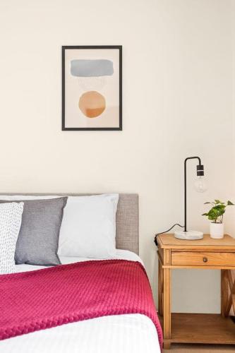 a bedroom with a bed and a table with a lamp at Tranquil Queen Room - Centrally Located at Milperra - Shared Bathroom in Panania