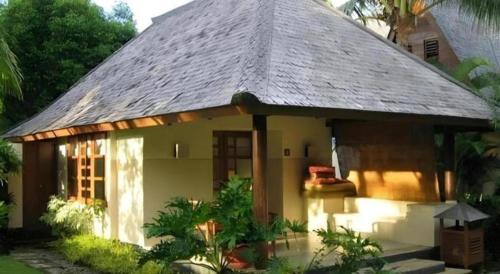 a small house with a thatched roof at Tanjung Lesung Beach Hotel in Carita