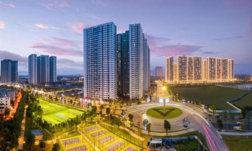 Una ciudad de noche con edificios altos y un parque. en Vinhomes Smart City Luxury Apartment, en Phú Thú