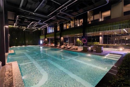 Una gran piscina en un edificio con sillas. en Vinhomes Smart City Luxury Apartment, en Phú Thú