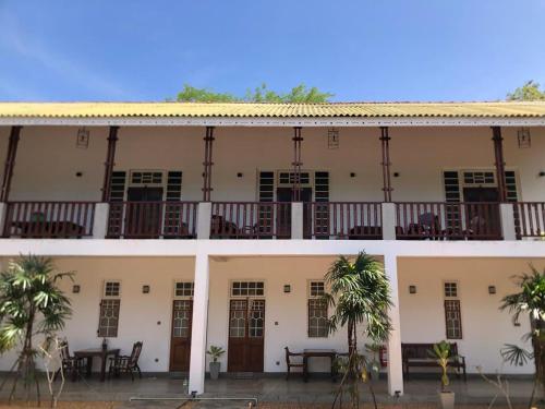 a building with tables and chairs on the balcony at Ovenro Hotel Yala, Kataragama in Kataragama