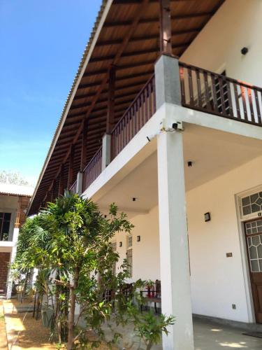 a house with a staircase on the side of it at Ovenro Hotel Yala, Kataragama in Kataragama