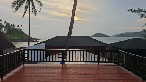 a wooden deck with a view of the water at The Ark Comforts in Palolem