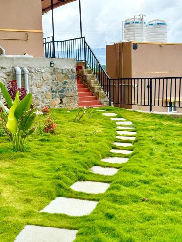 a walkway in the grass in front of a building at Humming Bird By Brown Tree Resorts in Kotagiri