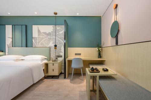 a hotel room with a bed and a desk at Jin Yi Youxuan Hotel Baotou Wanda Plaza Branch in Baotou