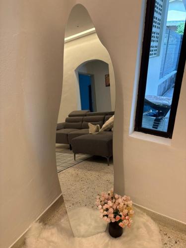 a living room with a mirror and a vase with flowers at Lock homestay in Kulai