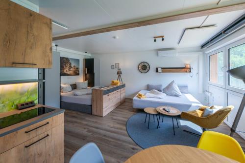 a bedroom with two beds and a living room at Stadel Chalet Kunterbunt in Ried im Oberinntal