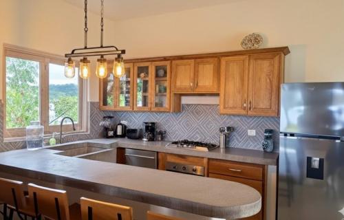 a kitchen with wooden cabinets and a stainless steel refrigerator at Casa Cerritos in Sayulita