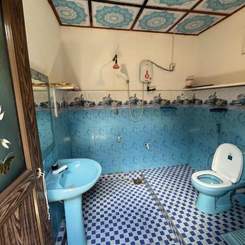 a blue bathroom with a sink and a toilet at House of Dorms in Ahangama
