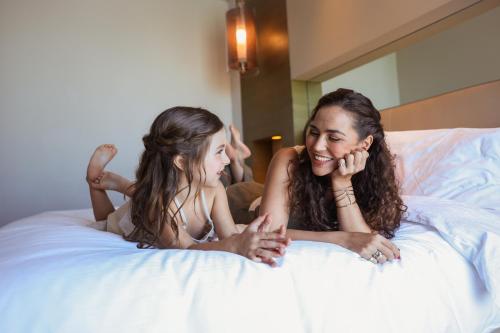 a woman and a little girl laying on a bed at Park Rotana Abu Dhabi in Abu Dhabi