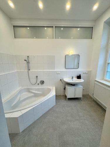 a white bathroom with a tub and a sink at Bavaria Home Modern Living in Geisenfeld