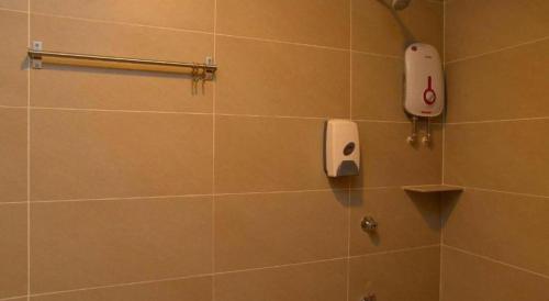 a bathroom with a shower with a phone on the wall at Sg. Paka Hotel in Paka
