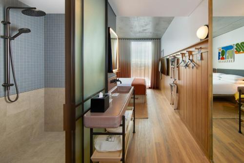 a hotel room with a shower and a bedroom at Moxy Sydney Airport in Sydney