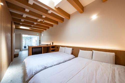 two beds in a room with wooden walls at Hotel 二灯 in Beppu