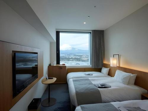 a hotel room with two beds and a large window at HOTEL CLAD in Fuji