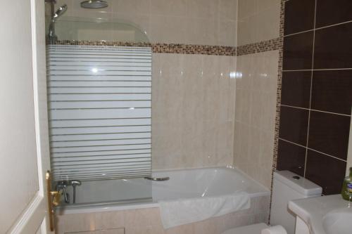 a bathroom with a bath tub and a toilet at Maison Tobias in Bussy-Saint-Georges