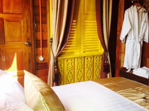 a bedroom with a bed and a yellow door at Kampong Pinang Sebatang Melaka in Melaka