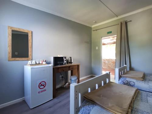 にあるWindygates Estate Room 3の小さな客室で、冷蔵庫、テーブルが備わります。