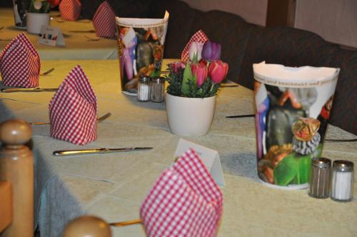 a table with red and white napkins and flowers on it at Hotel Gasthof Vogelsang in Zellingen