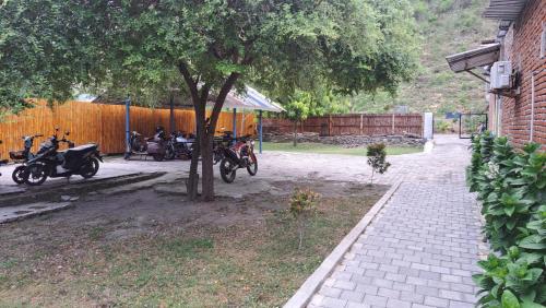 a group of motorcycles parked under a tree at Satu Hati Hotel in Ekas