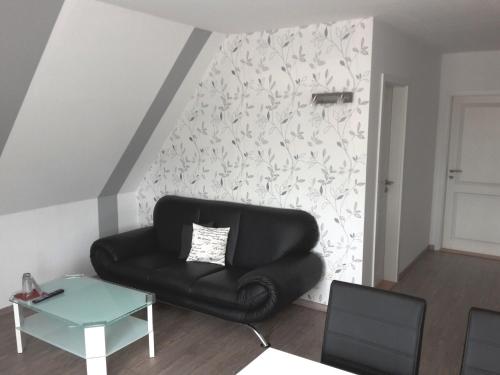 a black leather couch in a living room with a wall at Pension Marktblick in Friedrichstadt