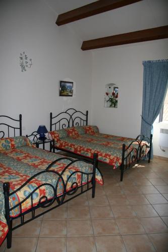 une chambre avec trois lits dans une pièce dans l'établissement Chambres D’hôtes Lou Jassou, à Lapanouse-de-Cernon